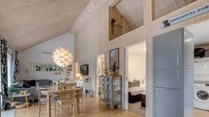 Ein modernes Interieur mit Essbereich, Küche und sichtbarer Waschküche.