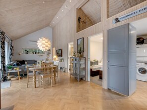 Ein modernes Interieur mit Essbereich, Küche und sichtbarer Waschküche.