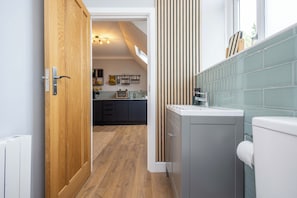 A modern kitchen with wooden cabinets, a grey countertop, and a window above the sink.