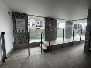 Ein moderner Poolbereich im Innenbereich mit Glasgeländern, Blick auf den Pool und einem Schild mit Poolregeln.