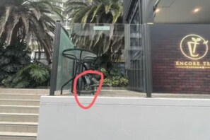 Ein Gebäude mit Glasfassade, Palmen und einem Schild mit Logo und Schrift.
