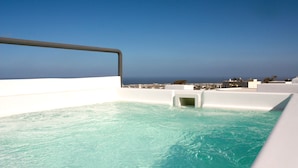 A rooftop infinity pool with a clear view of the ocean and cityscape. - The Petra Villa | Premium getaway blending modern luxury, authentic island charm (Thira)