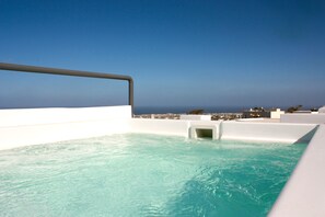 Ein Rooftop-Endlospool mit freiem Blick auf das Meer und die Skyline der Stadt.