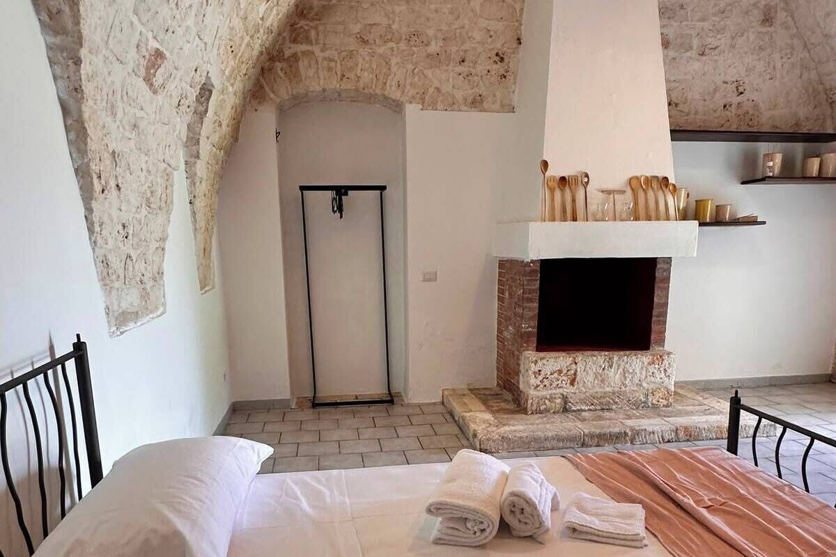 Un dormitorio con cama, chimenea y puerta.