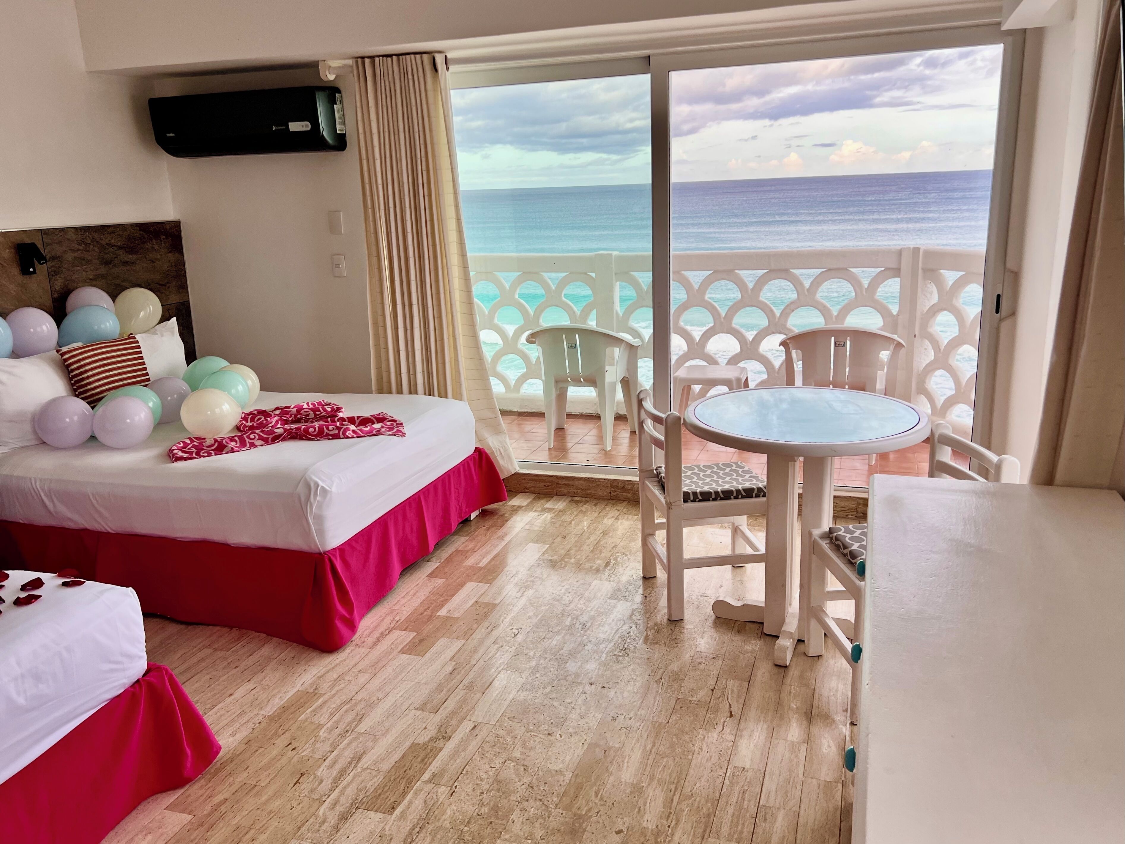Habitación de hotel con cama, una mesita y vistas al océano.