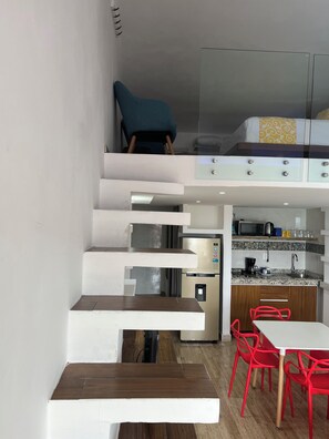 A compact kitchen with a microwave, coffee maker, and a water dispenser.