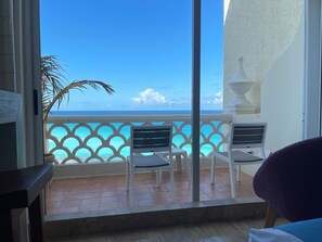 A balcony with a view of the ocean, white chairs, and a palm tree. - Ventanas al Paraiso Apartments Cancun (Cancun)