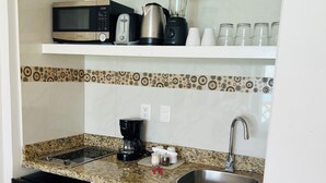 Una cocina compacta equipada con microondas, cafetera y lavavajillas.