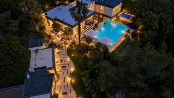Una casa moderna con piscina, immersa nel verde e con un patio ben illuminato.