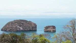 Paisatge costaner amb dues roques destacades i una vista clara del mar.