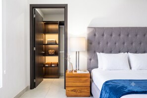 Ein Schlafzimmer mit einem Bett, einem Nachttisch, einer Lampe und einem Kleiderschrank.