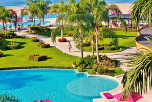 A resort with a large pool, palm trees, and a beach view. - Gran Venetian Resort Stay Oceanfront by Monyxbnb (Puerto Vallarta)
