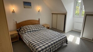 A bedroom with a bed, two bedside tables, a wardrobe, and a window. - NEW LISTING, Domaine de KER-PAULT, between St Cast and Matignon, 3-room cottage 5 minutes from... (MATIGNON)