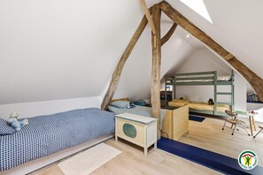 Ein Kinderzimmer mit Etagenbetten, einem Schreibtisch und einem Stuhl.