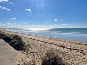 A beach with a concrete path, sandy shore, and sparse vegetation. - Ty Ar Mor Bras - MERLEVENEZ (MERLEVENEZ)