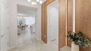Ein Flur mit einer Wand aus Holzvertäfelung, einer weißen Tür und einer Pflanze.
