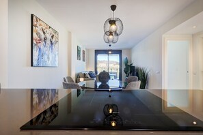 Ein modernes Interieur mit einem Glastisch, einer Chandelüster und einem Elefantenbild.