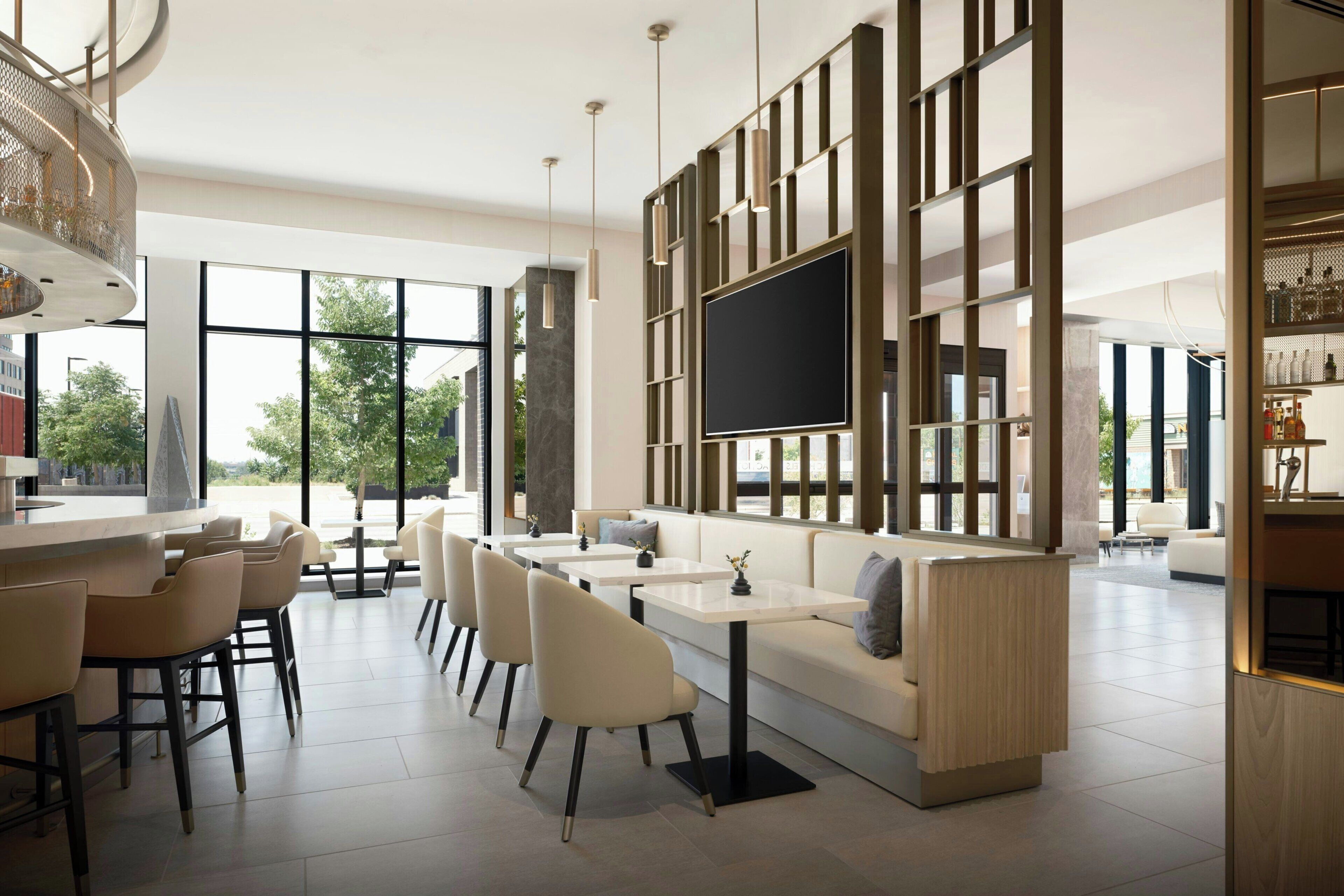 A modern interior with a bar area, seating, and a large TV screen.