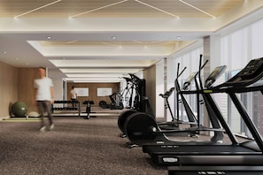 Un gimnasio moderno con cintas de correr, elípticas y pelotas de ejercicio.