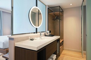 A modern bathroom with a large mirror, a sink, and a shower area. - AC Hotel Denver RiNo (Denver)