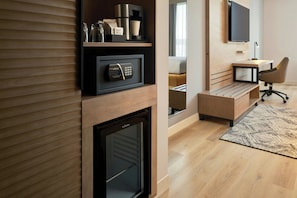 A modern room with a built-in safe, a coffee machine, and a desk with a chair. - AC Hotel Denver RiNo (Denver)