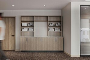 Un interior moderno con un armario empotrado, repisas con toallas dobladas y una puerta a la vista.