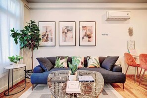Ein modernes Wohnzimmer mit einer Couch, einem Couchtisch und einer Topfpflanze.