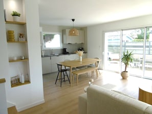 Eine moderne Küche mit Essbereich, Holzmöbeln und einem großen Fenster.
