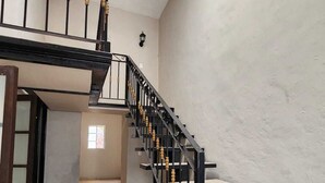 A staircase with black railings and wooden balusters, leading to a landing with a window.