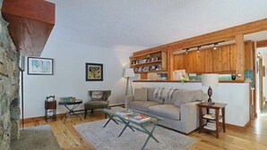 Een gezellige woonkamer met een bank, salontafel en een boekenplank.