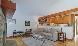 Ein gemütliches Wohnzimmer mit einer Couch, einem Couchtisch und einem Bücherregal.