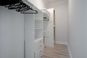 Un dressing avec des étagères, des tiroirs et une tringle pour suspendre les vêtements.