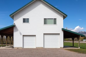 A two-story house with a covered driveway and two garage doors.
