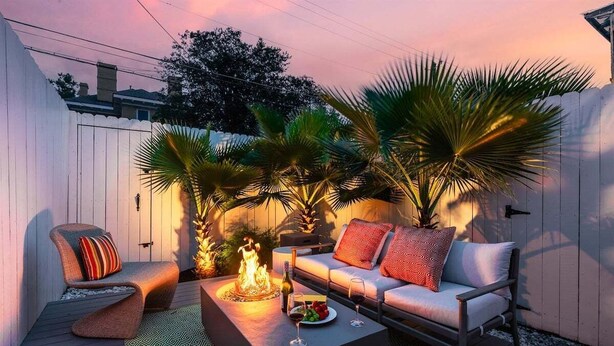 A patio with a sofa, a chair, a fire pit, and potted plants. - Downtown Savannah * 2 Bedroom * Firepit * Dogs OK * Private Patio (Savannah)