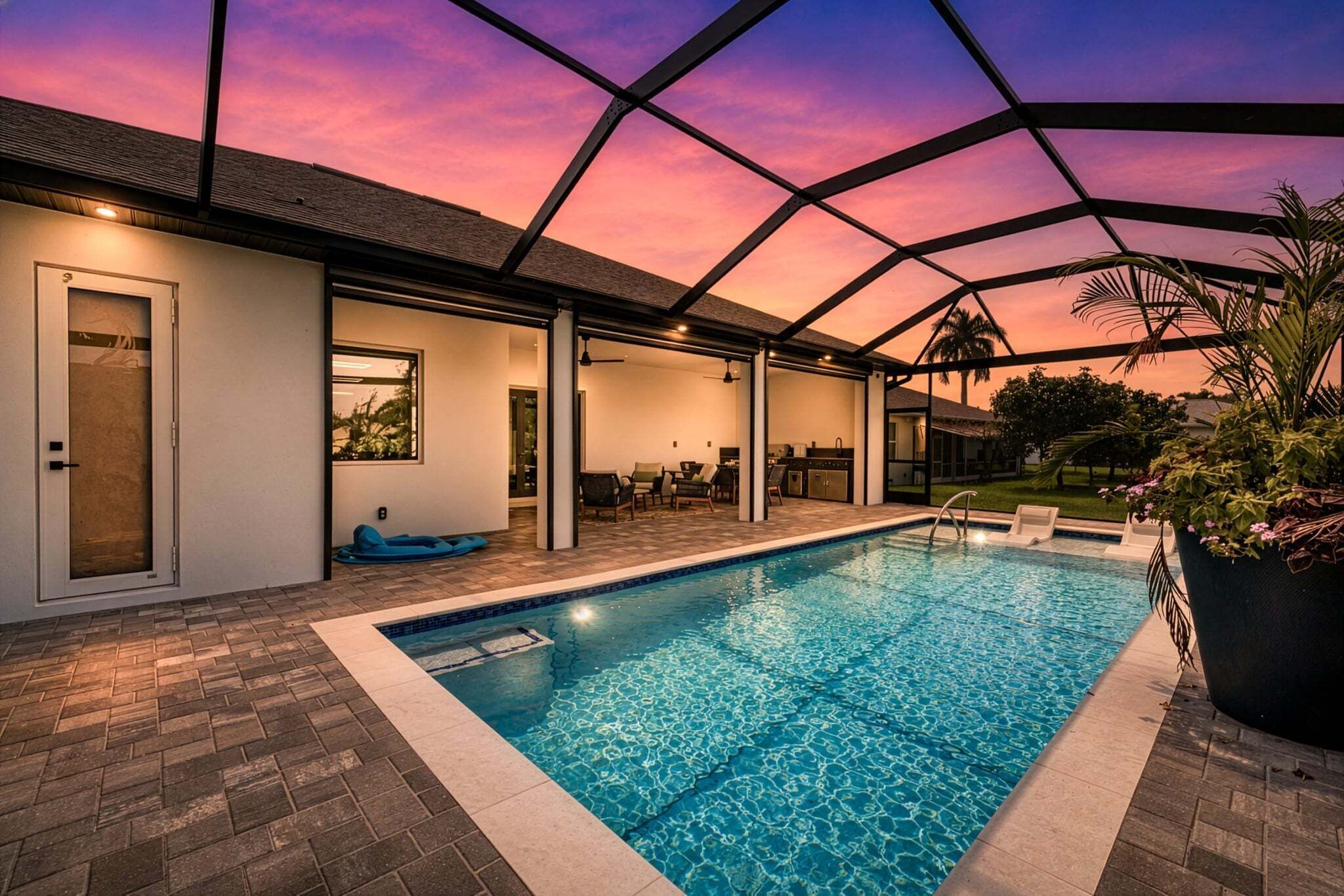 Una piscina con un patio techado, una puerta y vistas al cielo.