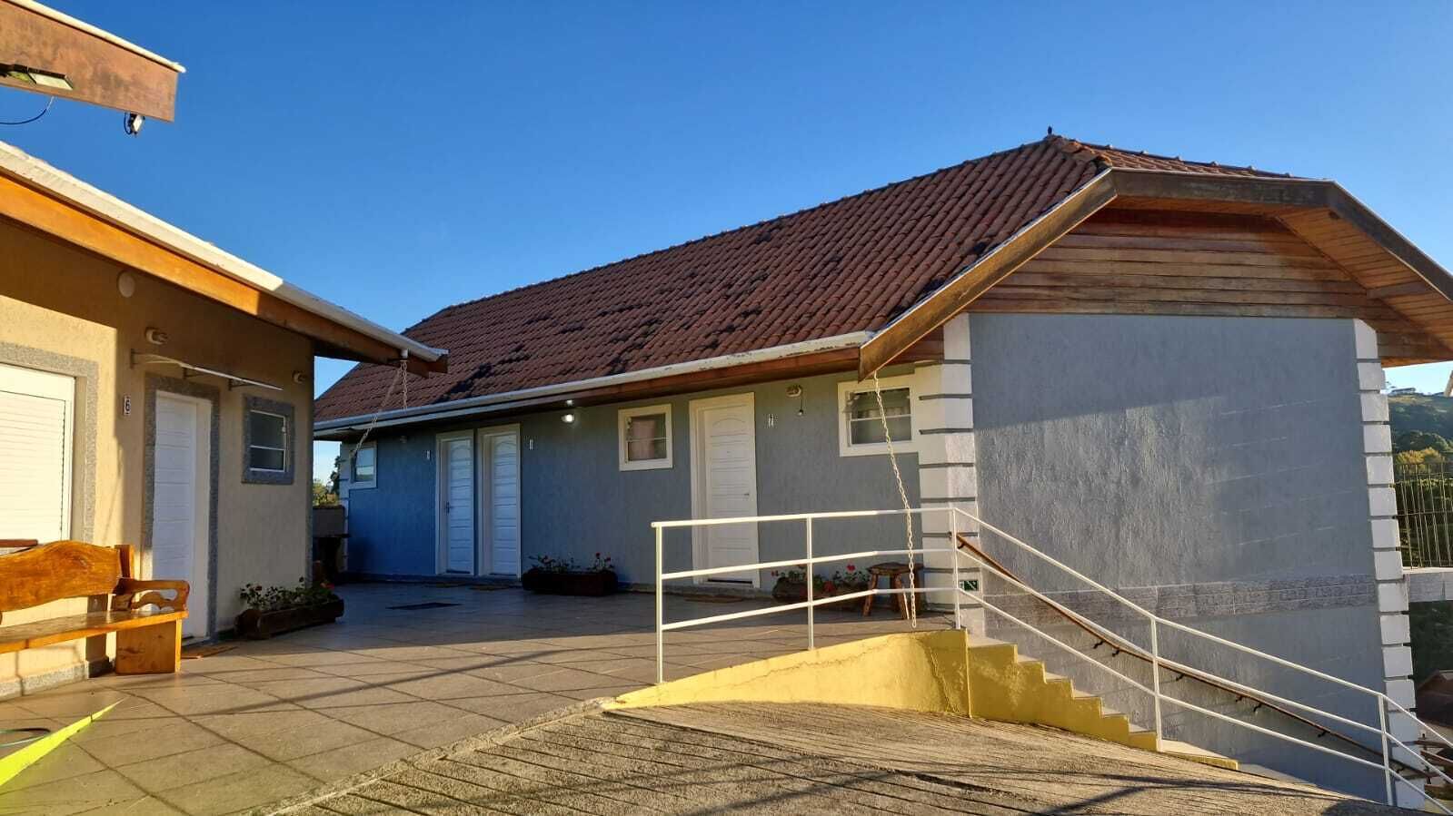 Un edificio con tejado de tejas, una escalera y un banco.