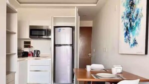 A compact kitchen with a refrigerator, microwave, and coffee maker. - Ocean-View King Studio with Private Balcony & Rooftop Pool (Playa del Carmen)