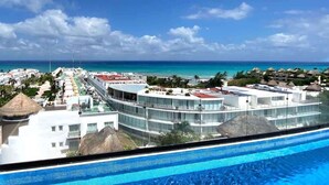 A resort with a pool, a view of the ocean, and a clear sky. - Ocean-View King Studio with Private Balcony & Rooftop Pool (Playa del Carmen)