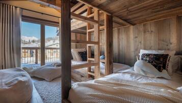 Habitación de cabaña de madera con una cama, una ventana y vistas a un paisaje nevado.