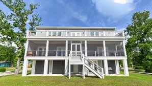 A two-story building with a balcony, a staircase, and a garage door.