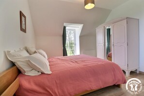 Une chambre à coucher avec un lit, une armoire et une fenêtre.