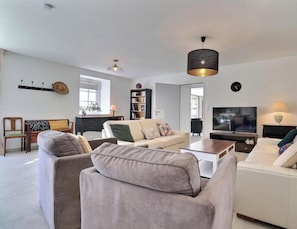 A modern living room with a sofa, armchairs, a TV, and a bookshelf. - L'Escale du Grand Bois (QUEBRIAC)
