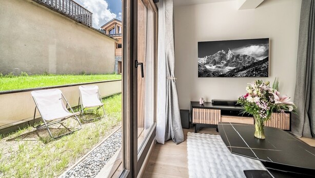 Ein modernes Zimmer mit einem großen Fenster, einem Esstisch, einem Fernseher und einem Gemälde.