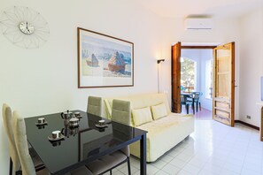 A modern living room with a glass table, sofa, and a painting on the wall. - El Sol by Casa di Marco (Campo Verde)
