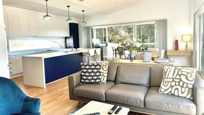 A modern living space with a kitchen, dining area, and a sofa with patterned cushions.