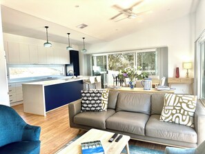 A modern living space with a kitchen, dining area, and a sofa with patterned cushions.