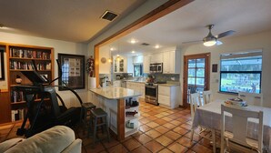Interior de uma casa com cozinha, sala de jantar e esteira na sala de estar.