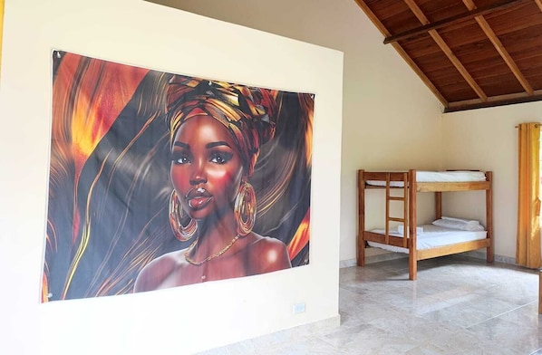 Una habitación con una cama litera, un cuadro grande en la pared y suelo de baldosas.