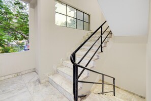 A staircase with marble steps and black metal railings. - Classic S Grand Residency (Hyderabad)