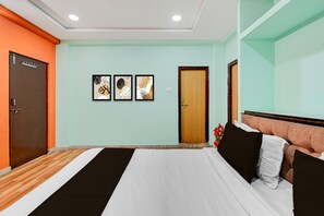 Une chambre à coucher avec un lit, une porte en bois et trois tableaux encadrés accrochés au mur.
